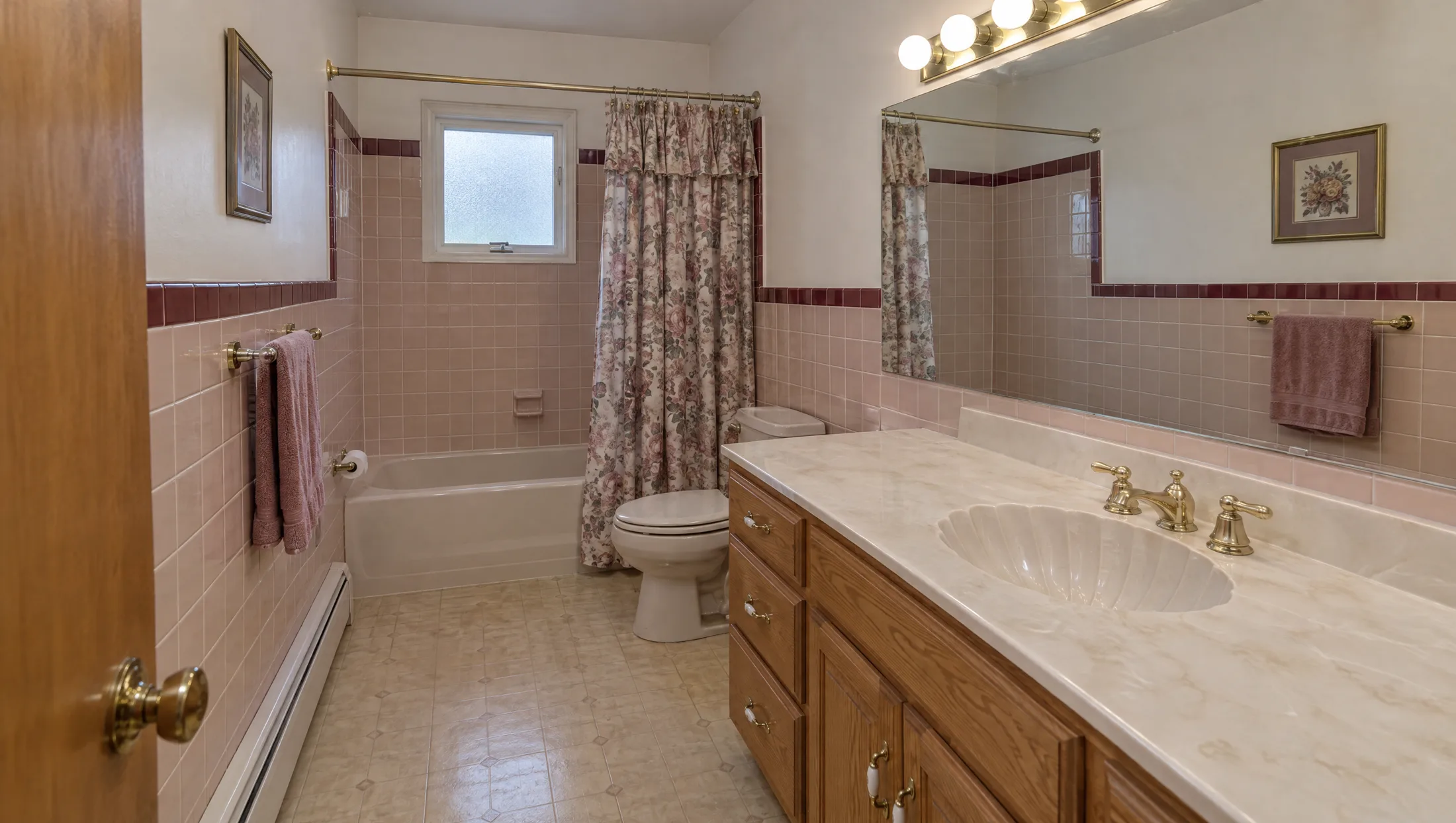 A 1992 pink tile bathroom transforming into a travertine spa bathroom with a stone soaking tub